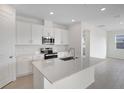 Modern kitchen with island, stainless steel appliances, and white cabinets at 4056 Bannock Ave, Tavares, FL 32778