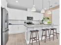 Modern kitchen with white cabinets, island, and three wooden stools at 4220 Sawtooth Ct, Tavares, FL 32778