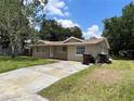 Tan single-story house with a spacious yard and driveway at 109 N Palm Ave, Kissimmee, FL 34741