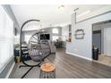 Open living area with gray walls, wood flooring, and a hanging chair at 104 Langham Dr, Davenport, FL 33897