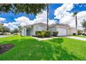 Charming light blue home with green landscaping and a palm tree at 104 Langham Dr, Davenport, FL 33897