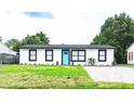 Newly renovated home with a modern exterior, paver driveway, and lawn at 1411 Overdale St, Orlando, FL 32825