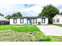 Updated home features a fresh exterior, paver driveway, and spacious lawn at 1411 Overdale St, Orlando, FL 32825