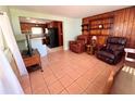Living room with tiled floors and leather furniture, open to kitchen at 1206 Osceola Ave, Tavares, FL 32778