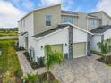 Modern two-story townhome with a two-car garage and stone accents at 9355 Sommerset Hills Dr # 9355, Davenport, FL 33896