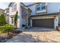 Two story house with a brown garage door and stone accents at 9032 Flamingo Key Way, Kissimmee, FL 34747