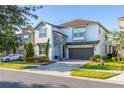 Two-story house with stone accents, a large garage, and landscaping at 9032 Flamingo Key Way, Kissimmee, FL 34747