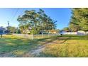 House with a white picket fence and large tree at 1501 Ne 57Th St, Ocala, FL 34479