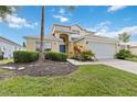 Two-story house with attached garage, landscaping, and driveway at 241 Grosvenor Loop, Davenport, FL 33897