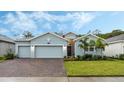 Light blue house with two-car garage and landscaped yard at 6282 Lakepine St, St Cloud, FL 34771