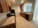 Kitchen with wood cabinets, black appliances, and tile floor at 4980 W Castle W St, Kissimmee, FL 34758
