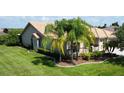 Landscaped property featuring a one-story home with tile roof and palm trees at 203 Escondido Ct, Poinciana, FL 34759