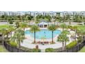 Community pool with palm trees and lounge chairs at 4721 Clock Tower Dr # 302, Kissimmee, FL 34746