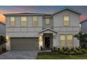 Two-story house with a gray garage door and landscaping at dusk at 3209 Lilac Way, Davenport, FL 33897