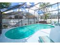 Enclosed kidney-shaped swimming pool with a spa and patio furniture at 162 Seneca Point Trl, Kissimmee, FL 34746