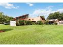 Mid-century modern home with a large lawn and carport at 50 2Nd St, Saint Cloud, FL 34769
