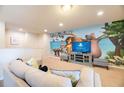Game room featuring a large TV, comfortable seating, and a playful mural at 9047 Rhodes St, Kissimmee, FL 34747