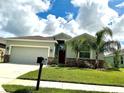 One-story home with 2-car garage, landscaping, and stone accents at 4183 Cortland Dr, Davenport, FL 33837