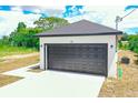 Attached garage with a dark-colored door at 48 Atlantic Ave, Babson Park, FL 33827