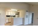 Well-lit kitchen featuring white cabinets and a breakfast bar at 2203 Key West Ct # 436, Kissimmee, FL 34741
