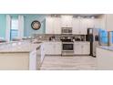 Modern kitchen with white cabinets, granite countertops, and stainless steel appliances at 1495 Rolling Fairways Dr, Davenport, FL 33896