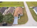 House with brown roof, gray driveway and a green lawn, viewed from above at 905 Knollwood Dr, Davenport, FL 33837