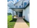 Two-story house with a modern facade, stone accents, and a covered porch at 1980 Poblado Ct, Kissimmee, FL 34744