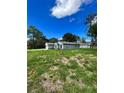New construction home with gray siding, large yard, and side view at 1339 Tallahassee Ct, Kissimmee, FL 34759