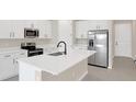 Modern kitchen with white cabinets, stainless steel appliances, and a large island at 4216 Sawtooth Ct, Tavares, FL 32778