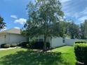 Side view of house with large tree and green lawn at 4311 Sw 53Rd Ter, Ocala, FL 34474