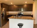 Modern kitchen with dark brown cabinets and granite countertops at 1523 Wynford Cir, Tavares, FL 32778