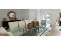 Glass-top dining table with white chairs and gold accents at 280 Pendant Ct, Kissimmee, FL 34747