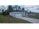 White garage with black trim and a concrete driveway at 2648 Sw 146 Th Place Rd, Ocala, FL 34473