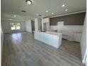 Modern kitchen with island, light wood cabinets, and white countertops at 1204 Vero Beach Way, Poinciana, FL 34759