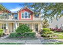 Two-story townhome with red and beige accents, front porch, and landscaped yard at 2917 Windmill Dr, Kissimmee, FL 34741