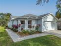 White house with gray roof, landscaping, and paved walkway at 205 Bell Tower W Xing, Kissimmee, FL 34759