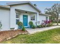 House exterior featuring a teal front door and well-manicured landscaping at 205 Bell Tower W Xing, Kissimmee, FL 34759