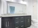 Bathroom boasts double vanity with granite top and dark wood cabinets at 623 Sylvan Ramble Rd, Davenport, FL 33837