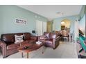 Open concept living room and dining area with leather sofas and view of kitchen at 2300 Silver Palm Dr # 303, Kissimmee, FL 34747