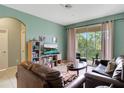 Spacious living room with leather sofas, large TV, and balcony access at 2300 Silver Palm Dr # 303, Kissimmee, FL 34747