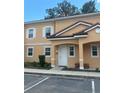 Exterior view of a tan building with white door and landscaping at 5706 Olga St, Kissimmee, FL 34746