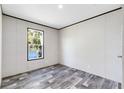 Bright bedroom with wood-look floors and window at 5303 Holopaw Rd, St Cloud, FL 34773