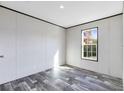 Simple bedroom with wood-look floors and window at 5303 Holopaw Rd, St Cloud, FL 34773