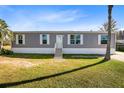 Gray manufactured home on a grassy lot at 5303 Holopaw Rd, St Cloud, FL 34773