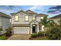 Two-story house with white exterior and a two-car garage at 8839 Interlocking Ct, Davenport, FL 33896
