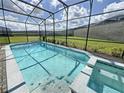 Screened-in pool and spa with a grassy backyard at 2290 Lelani Cir, Davenport, FL 33897