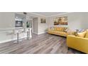 Living room with mustard yellow sofas and wood-look floors at 127 Oyster Bay Cir # 110, Altamonte Springs, FL 32701