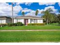 House with red front door, landscaped yard, and palm trees at 2918 Sunset Retreat Ct, Kissimmee, FL 34747