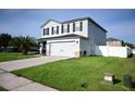 Two-story home with gray siding, black shutters, and a two-car garage at 1816 Stargazer Trl, Kissimmee, FL 34758