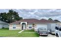 One-story house with a brown roof, tan exterior and a two-car garage at 324 Baccarat Ct, Kissimmee, FL 34759